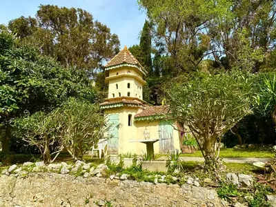 an old building with a tower in a garden at Appartement Spacieux dans une résidence Haut Standing in Cannes