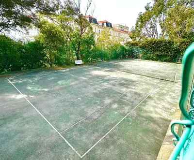 a tennis court with a net on top of it at Appartement Spacieux dans une résidence Haut Standing in Cannes