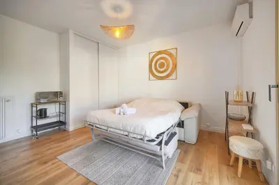 a white bedroom with a bed and a table at Lumineux studio LOGGIA, Alexandre III- proche CROISETTE A0B203 in Cannes