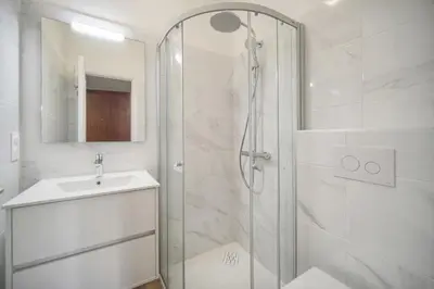 a white bathroom with a shower and a sink at Lumineux studio LOGGIA, Alexandre III- proche CROISETTE A0B203 in Cannes