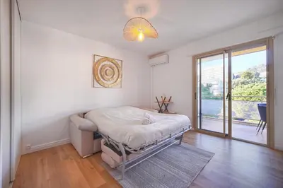 a bedroom with a bed and a large window at Lumineux studio LOGGIA, Alexandre III- proche CROISETTE A0B203 in Cannes