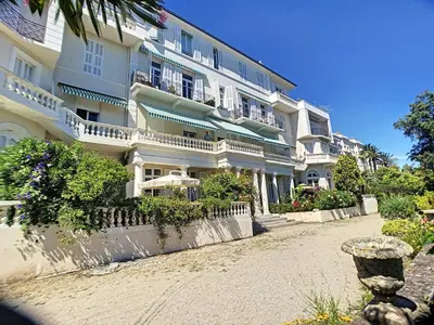 a large white building with balconies on a street at Charmant appartement en duplex 288L in Cannes