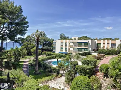 a resort with a swimming pool and a building at Superbe appartement plage du Midi 2 piscines 325L in Cannes