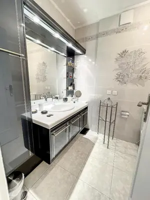 a bathroom with a sink and a large mirror at Superbe appartement plage du Midi 2 piscines 325L in Cannes