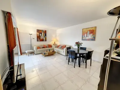 a living room with a couch and a table at Superbe appartement plage du Midi 2 piscines 325L in Cannes