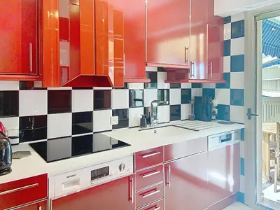 a kitchen with red and white tile on the wall at Superbe appartement plage du Midi 2 piscines 325L in Cannes