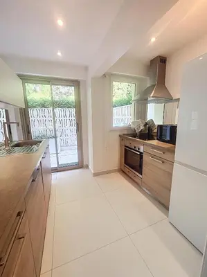 a large kitchen with a stove and a refrigerator at A deux pas des plages piscine 346L FRANCHI in Cannes