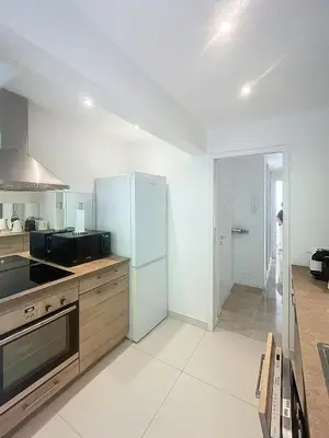 a kitchen with a refrigerator freezer in a room at A deux pas des plages piscine 346L FRANCHI in Cannes