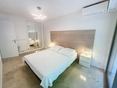 a bedroom with a white bed and a window at A deux pas des plages piscine 346L FRANCHI in Cannes