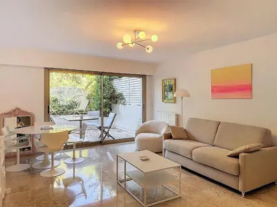 a living room with a couch and a table at A deux pas des plages piscine 346L FRANCHI in Cannes