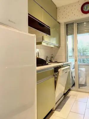 a white refrigerator in a kitchen with a window at A deux pas des plages du Midi 305L in Cannes