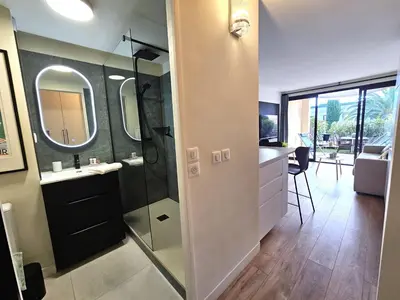 a bathroom with a shower and a sink and a mirror at Cannes - Superbe 2 pièces avec piscine - proche plages et centre in Cannes