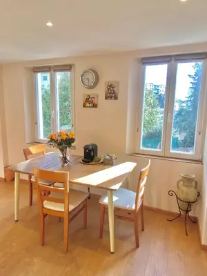a dining room with a table and chairs and windows at Great flat! 12 minute walk from train station and Palais in Cannes