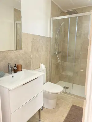 a white bathroom with a toilet and a shower at Great flat! 12 minute walk from train station and Palais in Cannes