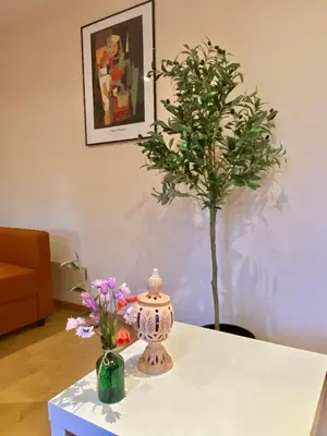 a table with a vase and a tree on it at Great flat! 12 minute walk from train station and Palais in Cannes