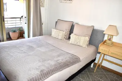 a bedroom with a large bed with pillows and a table at Charming Flat close to palais des festivals in Le Cannet