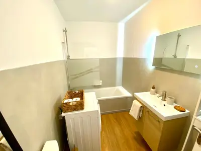 a white bathroom with a sink and a tub at Charming Flat close to palais des festivals in Le Cannet