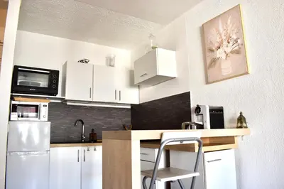 a kitchen with white cabinets and a counter top at Charming Flat close to palais des festivals in Le Cannet