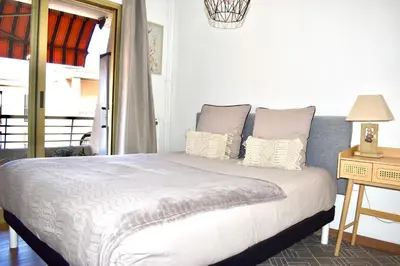 a bedroom with a bed and a table with a lamp at Charming Flat close to palais des festivals in Le Cannet