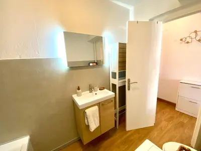 a small bathroom with a sink and a cabinet at Charming Flat close to palais des festivals in Le Cannet