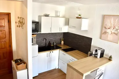 a kitchen with white cabinets and a counter top at Charming Flat close to palais des festivals in Le Cannet
