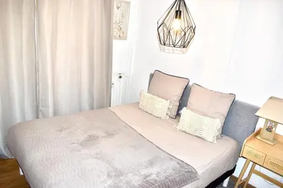 a bedroom with a bed with white sheets and pillows at Charming Flat close to palais des festivals in Le Cannet