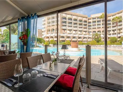 a dining room with a table and a swimming pool at Beautiful apartment with sea view in Cannes 5 pers in Cannes