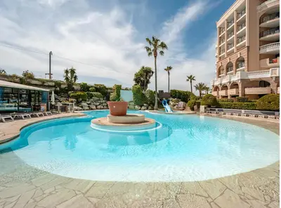 a large swimming pool in front of a building at Beautiful apartment with sea view in Cannes 5 pers in Cannes