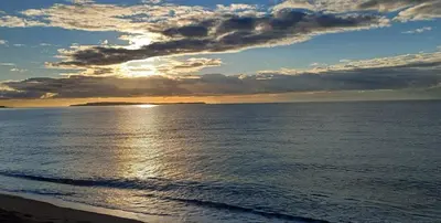a view of the ocean with the sun setting at Beautiful apartment with sea view in Cannes 5 pers in Cannes