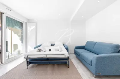 a living room with a blue couch and a coffee table at Le Maubourg - Cannes terrasse near Beaches in Cannes