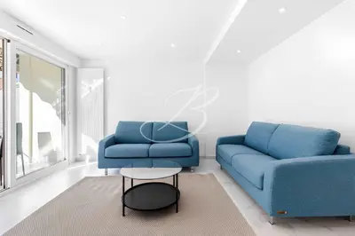 a living room with two blue couches and a table at Le Maubourg - Cannes terrasse near Beaches in Cannes