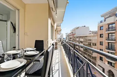 a balcony with tables and chairs and a view of a city at Le Maubourg - Cannes terrasse near Beaches in Cannes