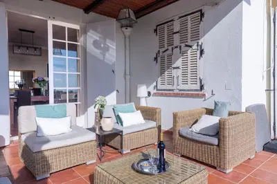 a patio with a table and chairs and a tree at Villa Roxane in Vallauris