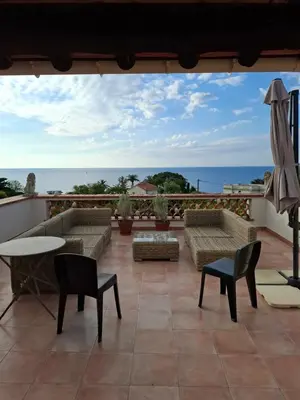 a kitchen with wooden cabinets and a vase of flowers on a table at Villa Roxane in Vallauris