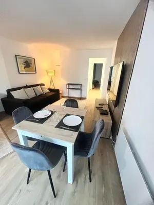 a living room with a table and chairs and a couch at Cosy a 3 min de la plage avec parking privé in Cannes