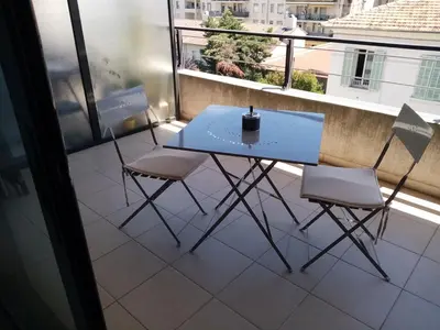 a blue table and two chairs on a balcony at Studio centre Cannes, piscine, climatisation in Cannes