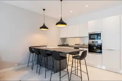a kitchen with a black table and stools at 3 bedrooms 3 bath Bivouac 2 min Palais in Cannes