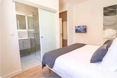 a bedroom with a large bed and a shower at 3 bedrooms 3 bath Bivouac 2 min Palais in Cannes