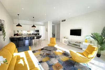 a living room with a yellow couch and a table at 3 bedrooms 3 bath Bivouac 2 min Palais in Cannes
