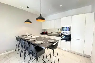 a kitchen with a dining room table with black chairs at 3 bedrooms 3 bath Bivouac 2 min Palais in Cannes