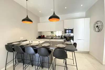 a kitchen with a large dining table with black chairs at 3 bedrooms 3 bath Bivouac 2 min Palais in Cannes