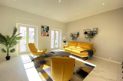 a living room with a yellow couch and chairs at 3 bedrooms 3 bath Bivouac 2 min Palais in Cannes