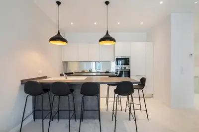 a kitchen with black stools around a kitchen island at 3 bedrooms 3 bath Bivouac 2 min Palais in Cannes
