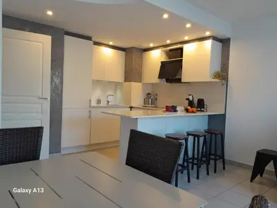 a kitchen with white cabinets and a table and chairs at Cannes Centre-Ville, Clim, WiFi 2-4P in Cannes