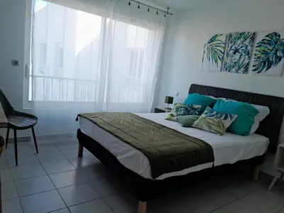 a bedroom with a bed with blue pillows and a window at Cannes Centre-Ville, Clim, WiFi 2-4P in Cannes