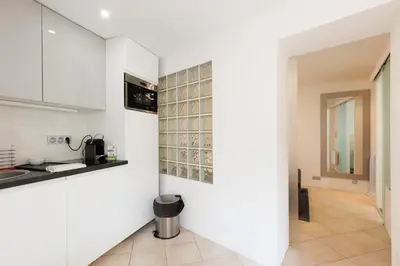a kitchen with white cabinets and a tile floor at Immogroom - Suquet - Vieux Port - Charmant T2 in Cannes