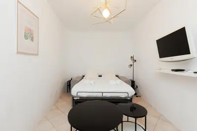 a white room with a bed and a tv at Immogroom - Suquet - Vieux Port - Charmant T2 in Cannes