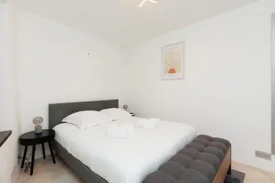 a bedroom with a large white bed and a couch at Immogroom - Suquet - Vieux Port - Charmant T2 in Cannes