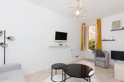 a living room with a table and a tv at Immogroom - Suquet - Vieux Port - Charmant T2 in Cannes