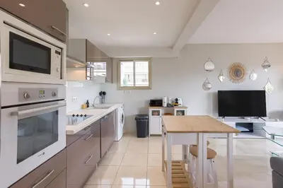 a kitchen with a wooden table and a kitchen with a counter at Cannes 77 - Terrasse, spacieux, clim, paisible in Cannes